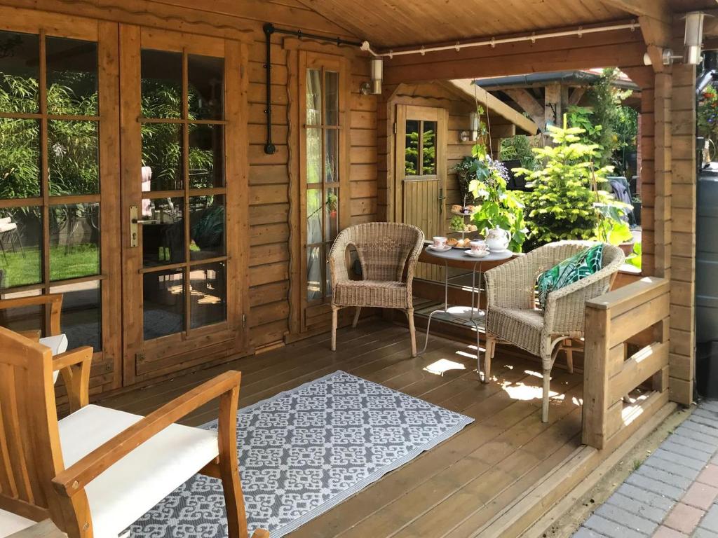 een veranda van een hut met een tafel en stoelen bij Oakwell Lodge in Rainham