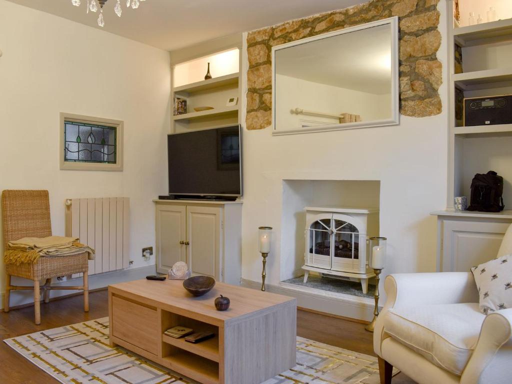 a living room with a couch and a fireplace at Plum Cottage in Castle Cary
