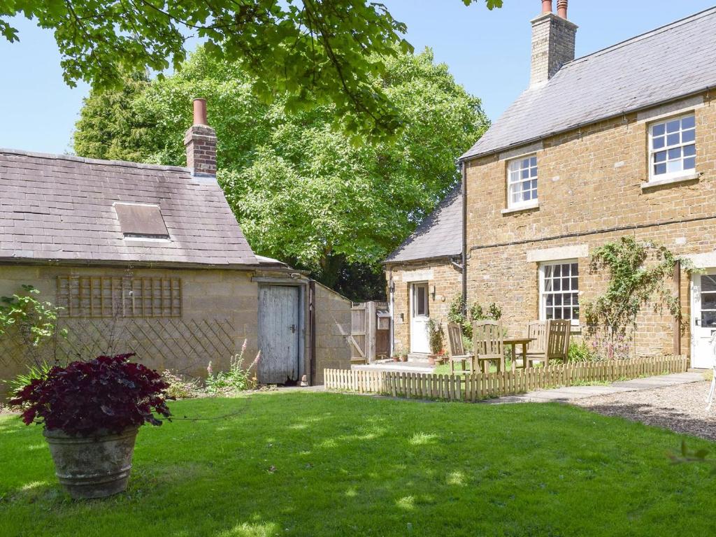 an exterior view of a house with a yard at Cooks Cottage in Knossington