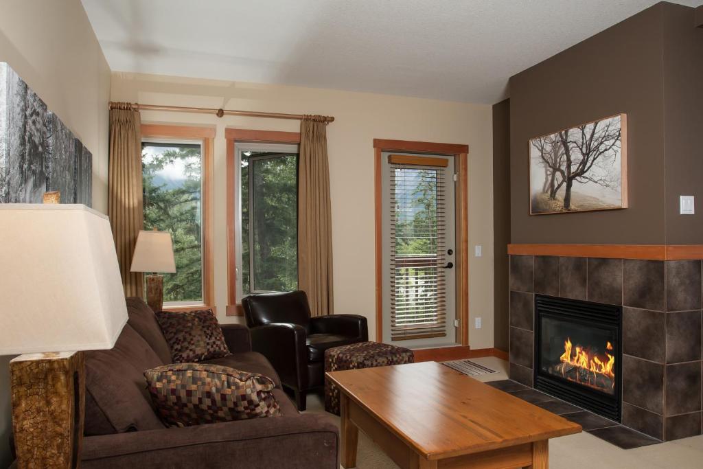 a living room with a couch and a fireplace at Lodges at Canmore in Canmore
