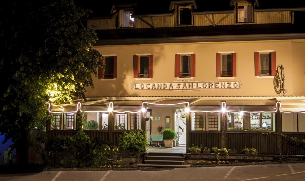 a hotel at night with lights on the facade at Locanda San Lorenzo in Puos dʼAlpago