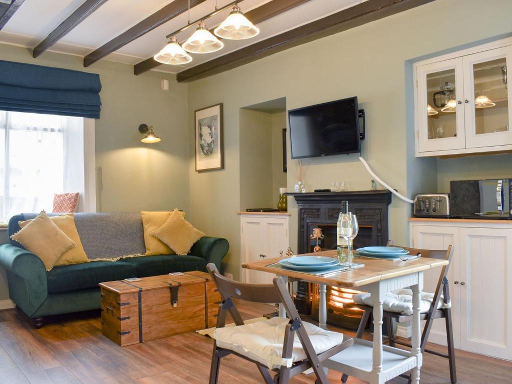 een woonkamer met een bank en een tafel bij Beck View Cottage in Staithes