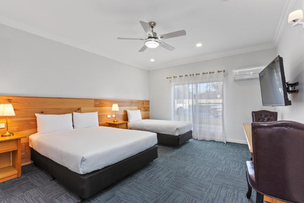 ein Hotelzimmer mit 2 Betten und einem Flachbild-TV in der Unterkunft The International Motel in Apollo Bay