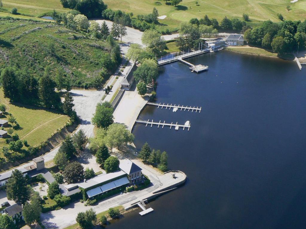 an aerial view of a lake with a boat dock at Logis Hotel du Lac in Neuvic