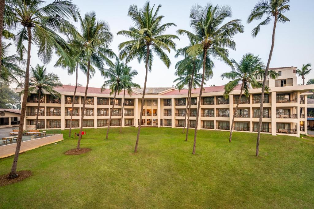 an exterior view of a building with palm trees at Silver Waves Resort & Spa Daman, a member of Radisson Individuals in Daman