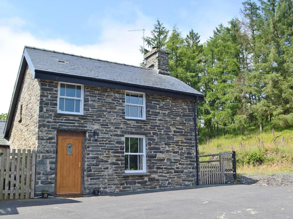 a stone house with a brown door and a fence at Uk34913 - Bwlchgraig Fach in Nantcwnlle