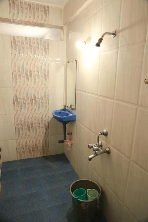 a bathroom with a blue sink and a bucket at Dreamcatcher House & Hostel at Arambol Beach in Arambol