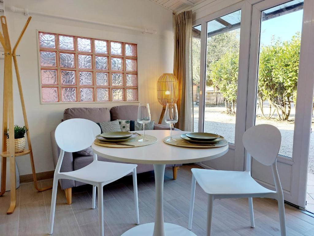 a dining room with a white table and chairs at Ravissant T2 terrasse privative et parking in Odos