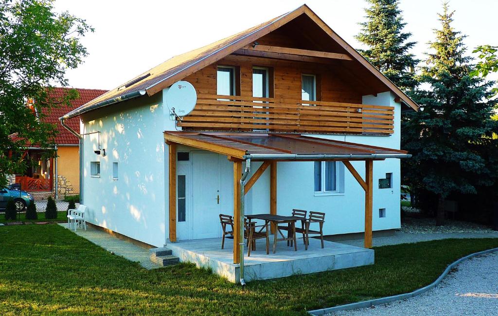 Casa con terraza con mesa y sillas en Levendula apartman en Kehidakustány