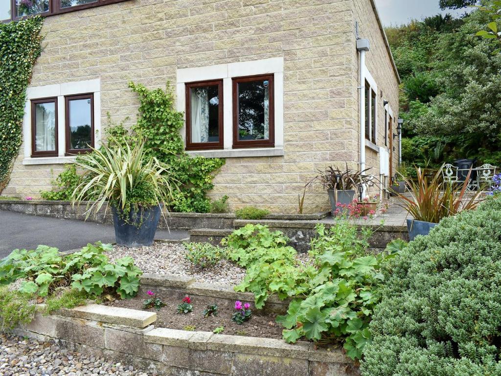 a garden in front of a house with plants at Quarry Cottage in Highpeak Junction