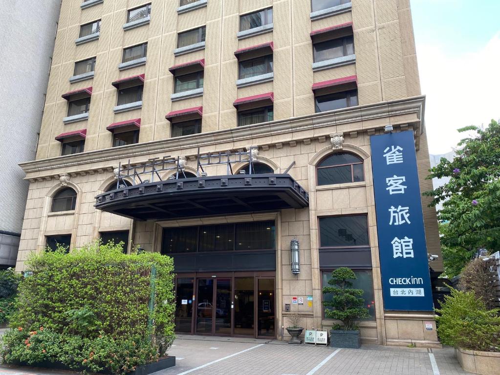 a building with a sign in front of it at CHECK inn Taipei Neihu in Taipei