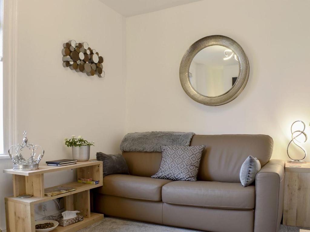 a living room with a couch and a mirror at Hidden Gem in Willingham