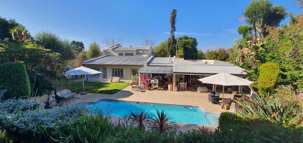 a house with a swimming pool in front of a house at PepperTree Guest House Paulshof Jhb Solar No Loadshedding in Johannesburg