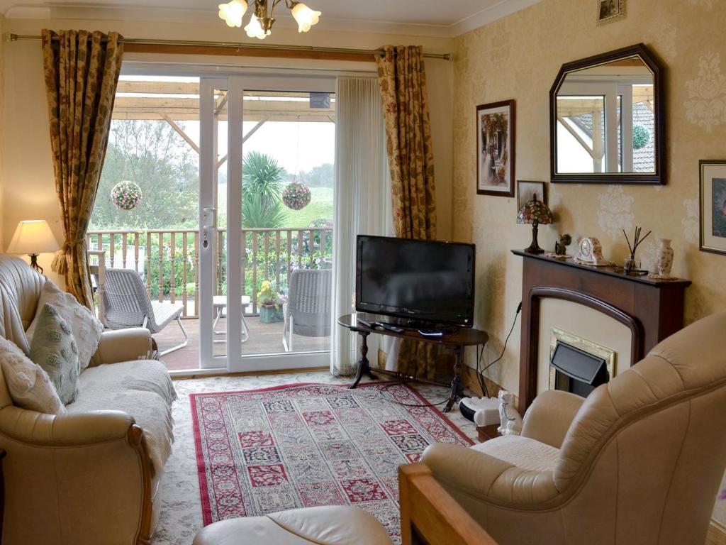 a living room with a fireplace and a television at Hilltop - East Wing in Newton Stewart