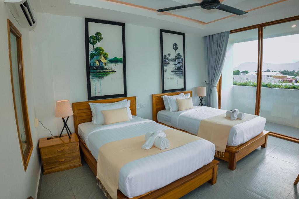 a hotel room with two beds and a window at Montagne Boutique in Kampot