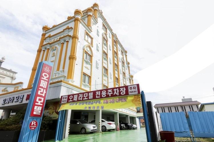 een groot gebouw met borden ervoor bij Opera Motel in Yeosu