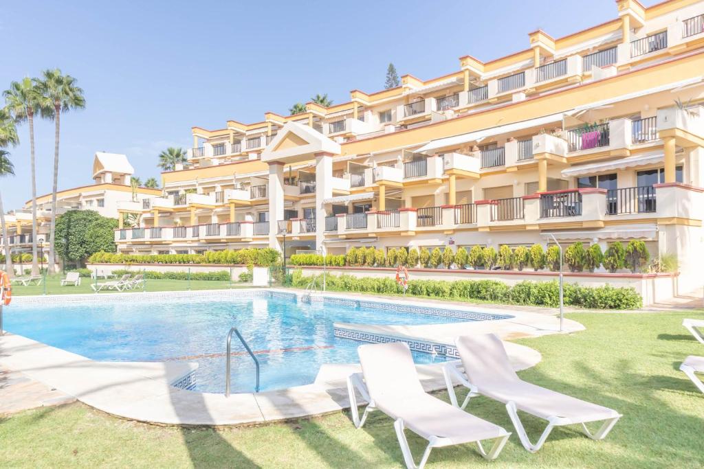 un hotel con piscina frente a un edificio en Romana Playa Beach Pool Paradise - Happy Rentals, en Marbella