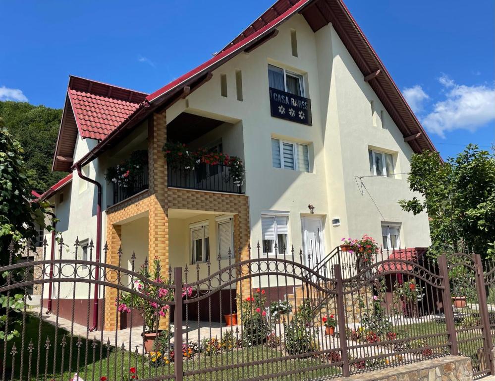a house with a fence in front of it at Pensiunea casa Rareș in Curtea de Argeş