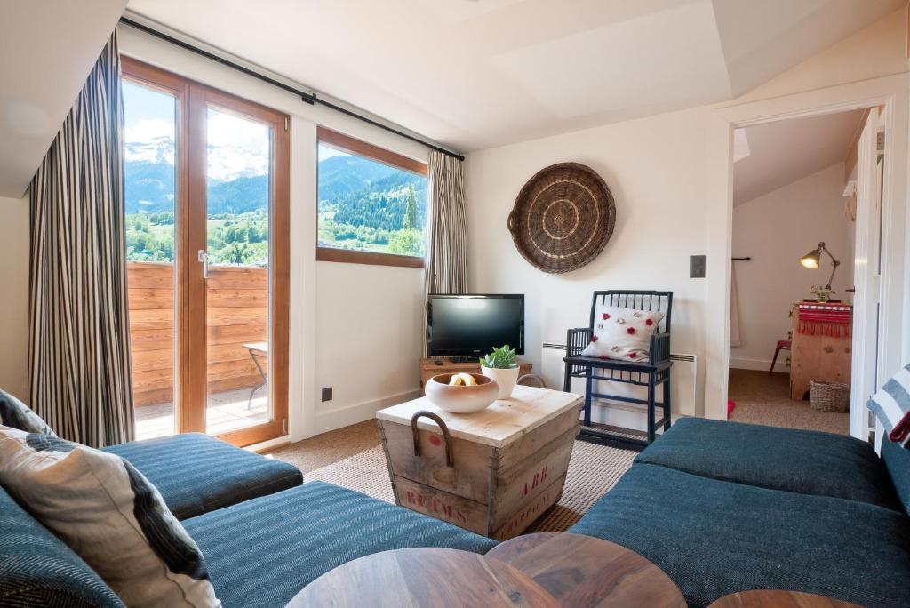 a living room with two beds and a television at La Ruinette - Boutique Apartments in Le Châble