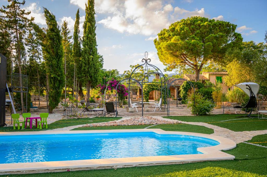una piscina in un giardino con parco giochi di Sa Caseta de Santa Maria a Santa Maria del Camí