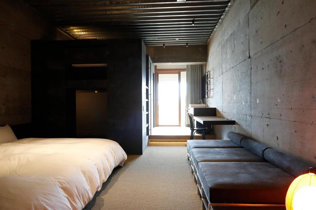 a bedroom with a bed and a couch and a desk at Matsumoto Jujo in Matsumoto