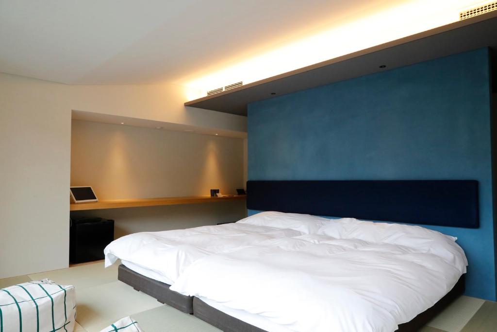 a bedroom with a large bed with a blue wall at Matsumoto Jujo in Matsumoto