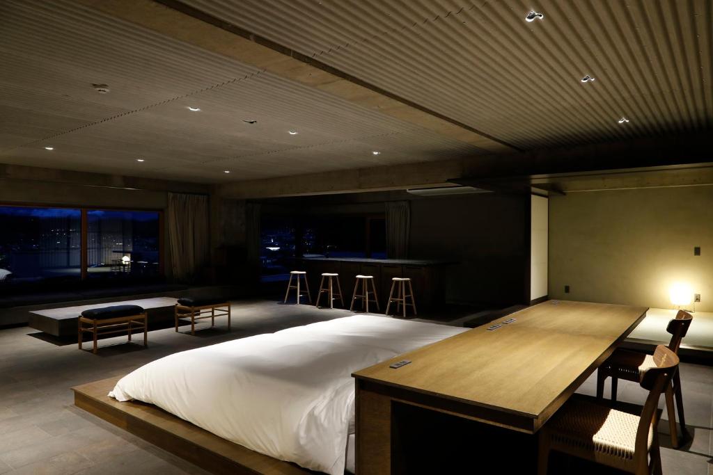 a bedroom with a bed and a table and chairs at Matsumoto Jujo in Matsumoto