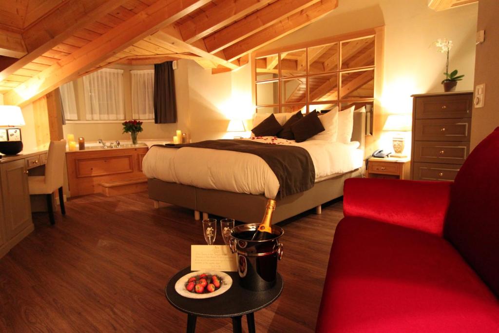 a hotel room with a bed and a table with a bowl of fruit at Hotel Albatros in Zermatt