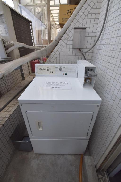 a white appliance sitting in a room with a wall at Inn Cube - Ximen in Taipei