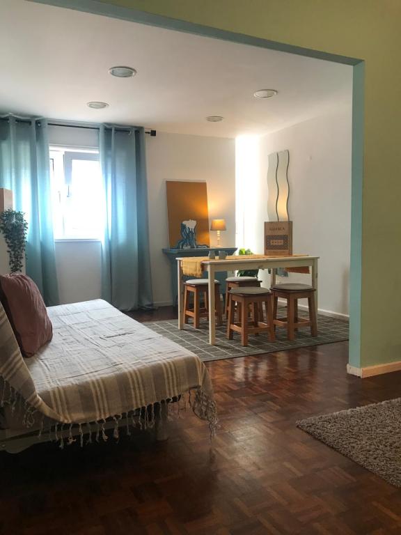 uma sala de estar com uma cama e uma mesa em Ria do Sal em Aveiro