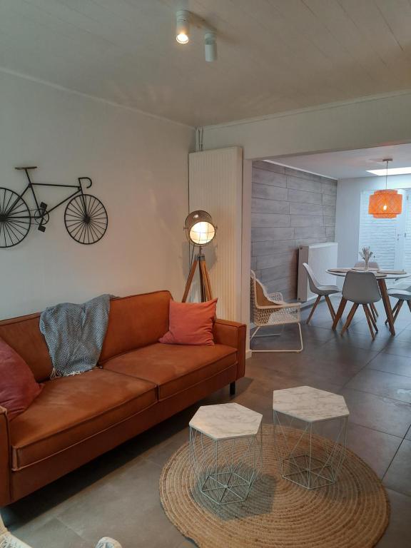 a living room with a couch and a bike on the wall at Huisje op de Muur van Geraardsbergen in Geraardsbergen