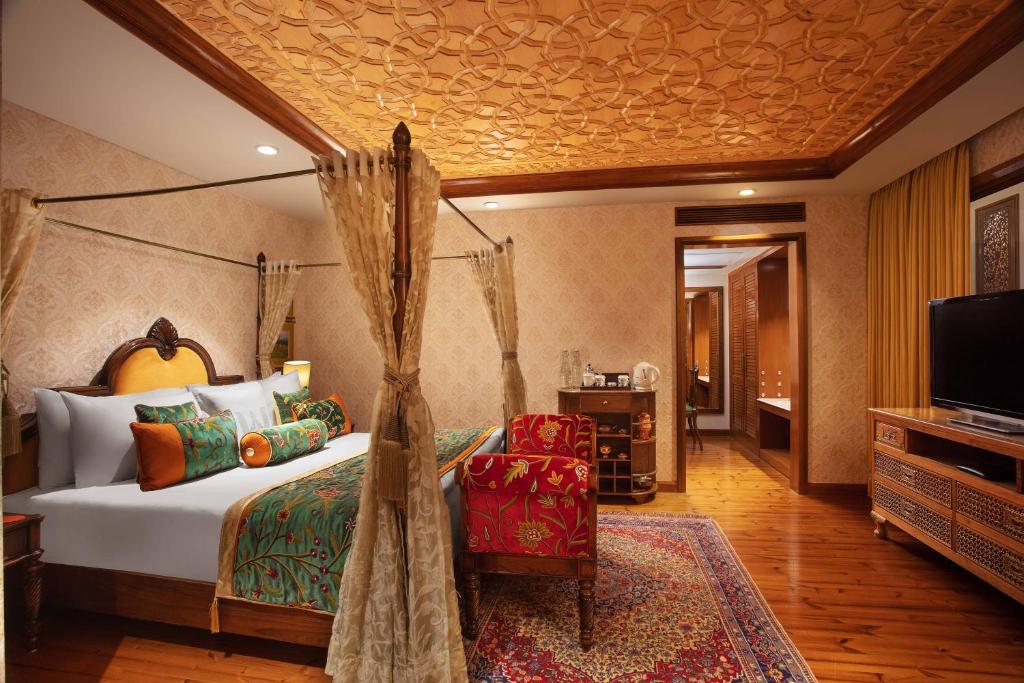 a bedroom with a canopy bed and a tv at Welcomhotel by ITC Hotels, Pine N Peak, Pahalgam in Pahalgām