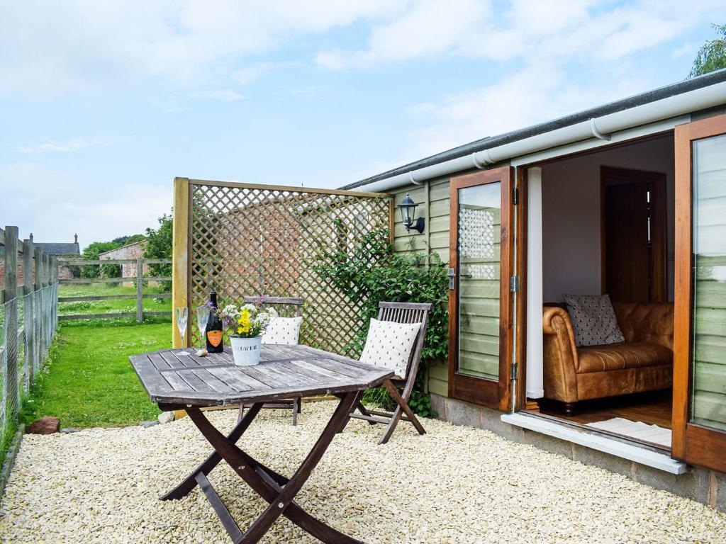 a small patio with a table and a couch at The Summerhouse - Uk34933 in Baschurch