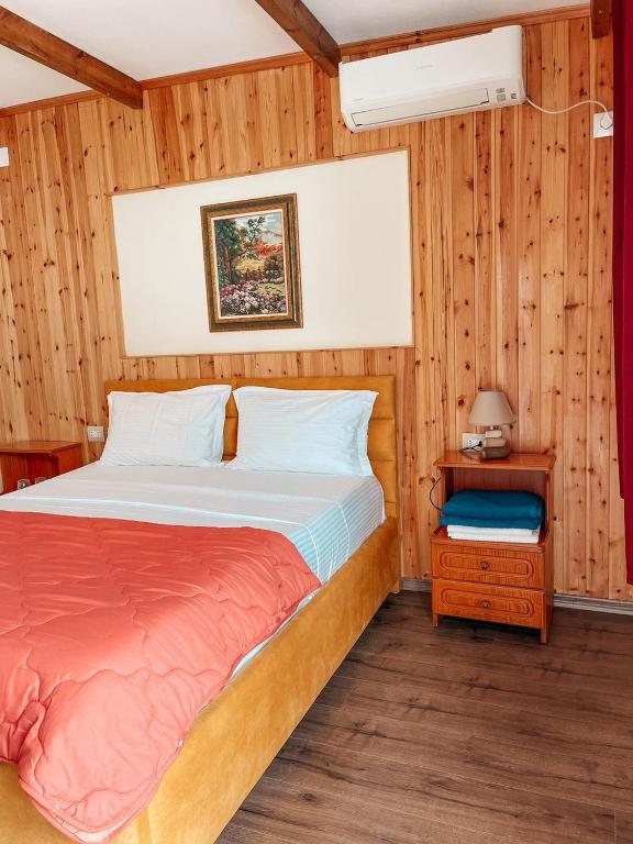 a bedroom with a bed and a table with a nightstand at Guesthouse Lord Byron in Tepelenë