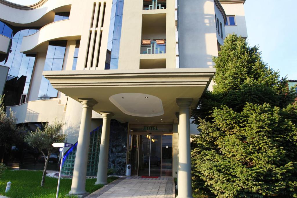 a building with a walkway in front of it at Hotel Green in Tirana