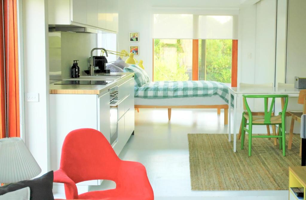 a kitchen with a sink and a red chair in it at wild coastal St Andrews Beach in Saint Andrews Beach