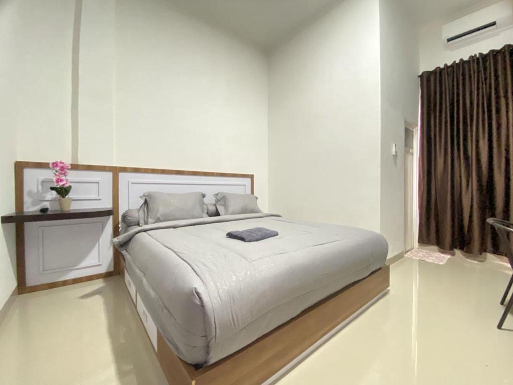 Un dormitorio blanco con una cama grande y una ventana en MJ Guest House Pusat Kota Malili Mitra RedDoorz, en Malili