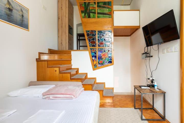 ein Schlafzimmer mit einer Treppe, einem Bett und einem TV in der Unterkunft Peace near the city center in Zagreb