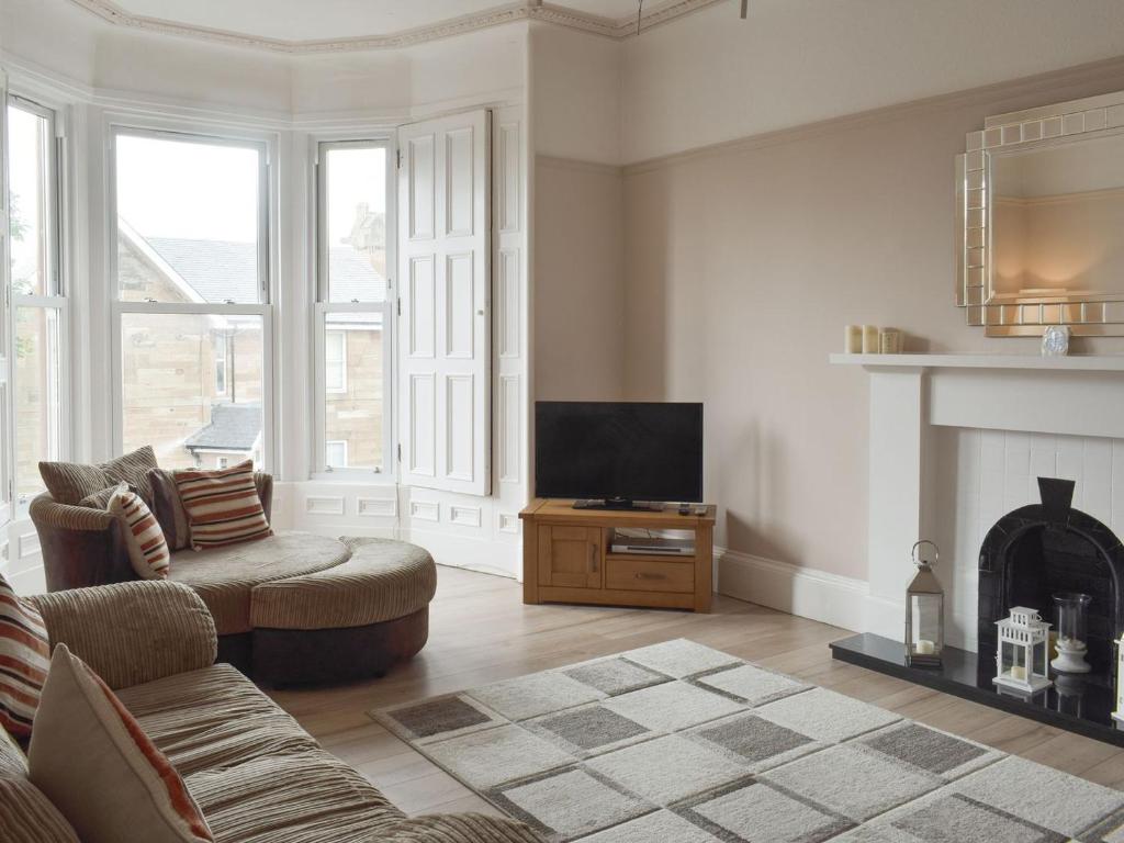 a living room with a tv and a fireplace at Charlotte Street in Ayr