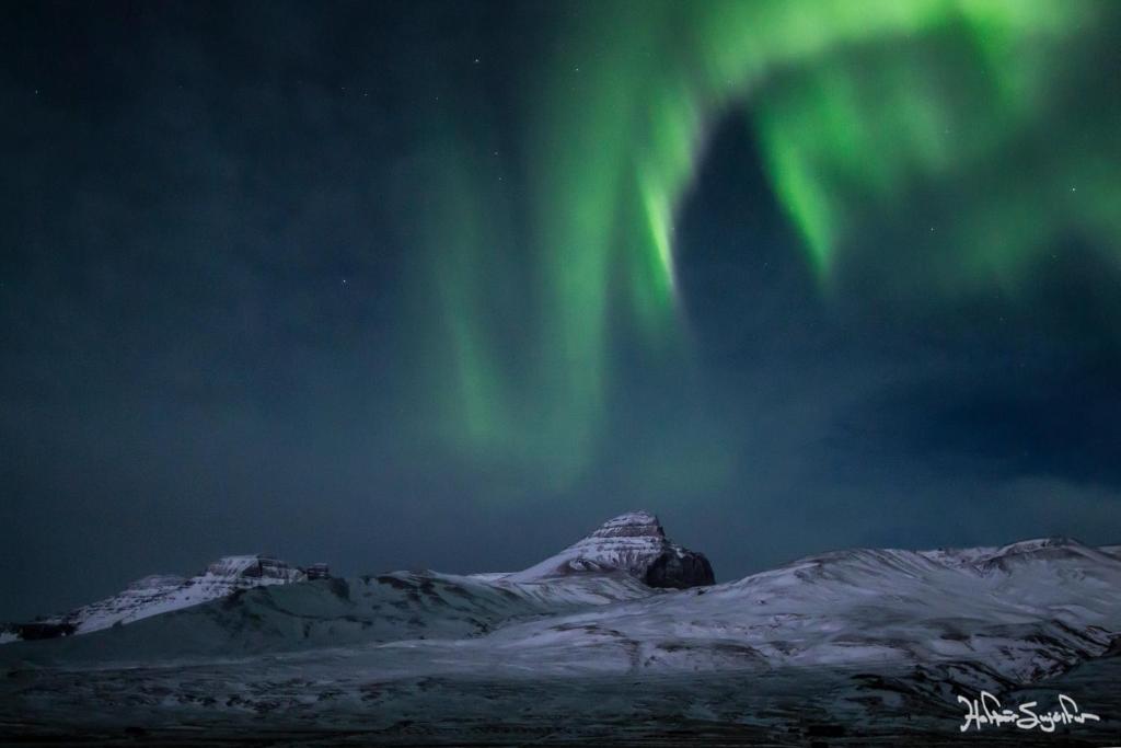 an image of the aurora in the sky over a mountain at Blabjorg Resort in Borgarfjordur Eystri