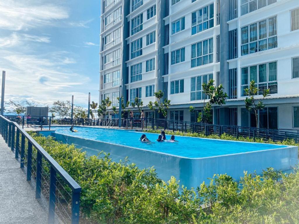 une piscine en face d'un bâtiment dans l'établissement Aina Staycation, Metrocity, à Kuching