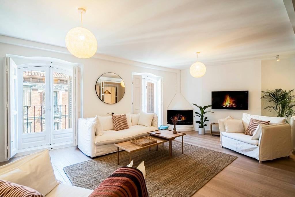 ein Wohnzimmer mit weißen Möbeln und einem Kamin in der Unterkunft Ever House - Atocha1 Superb-Location in Madrid