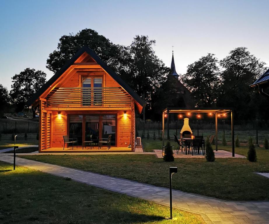 een kleine houten hut met een tafel in het gras bij Sauna balia - Nowa Osada Domki przy plaży - całoroczne domki na Mazurach in Ryn