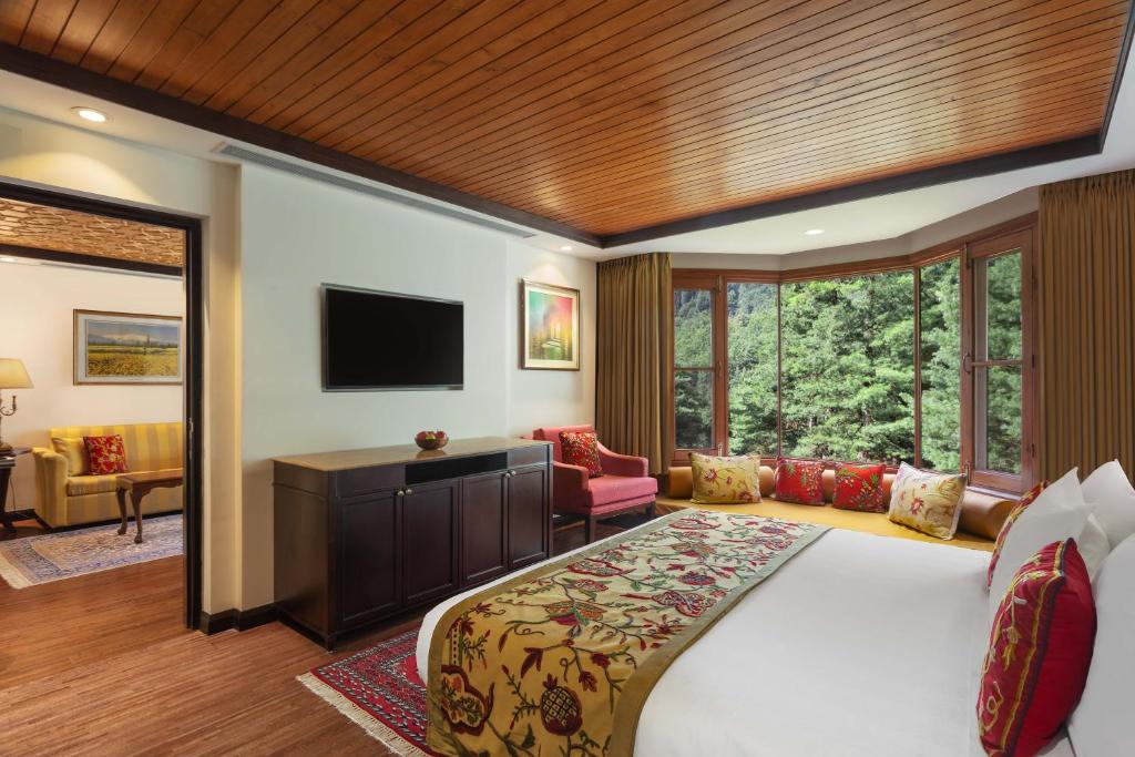 a bedroom with a large bed and a television at Welcomhotel by ITC Hotels, Pine N Peak, Pahalgam in Pahalgām