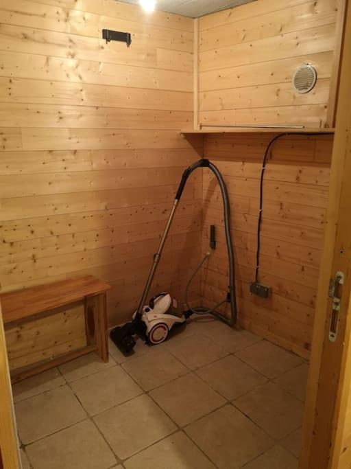 łazienka z odkurzaczem w drewnianej ścianie w obiekcie Coquet T1 hyper centre w mieście Le Bourg-dʼOisans