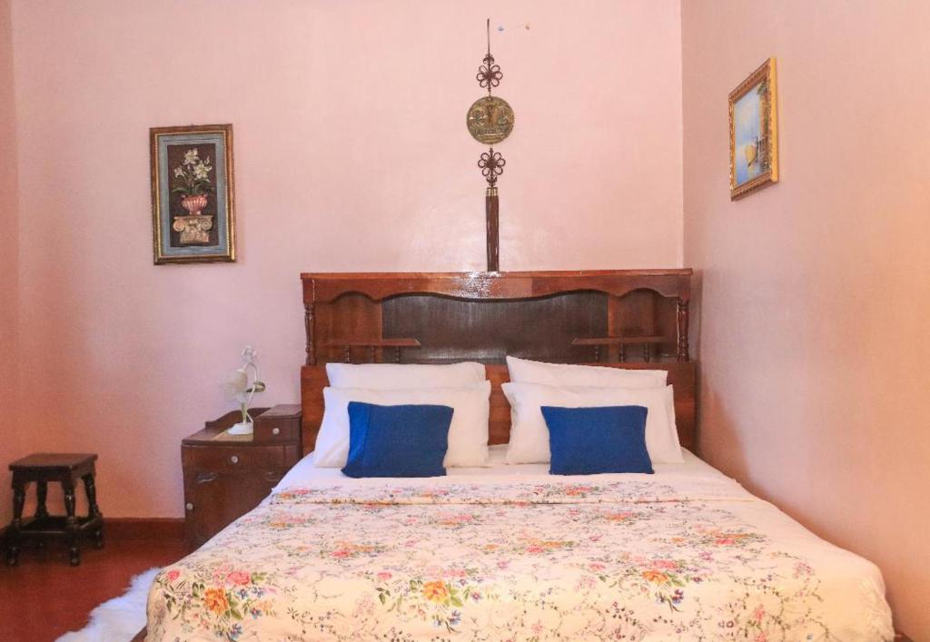 een slaapkamer met een groot bed met blauwe kussens bij Nyahururu Highlands Heaven -BnB in Nyahururu
