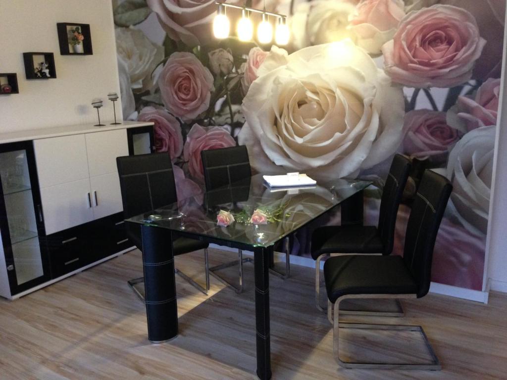 uma sala de jantar com uma mesa e um mural de rosas em Ferienwohnung Worms em Worms