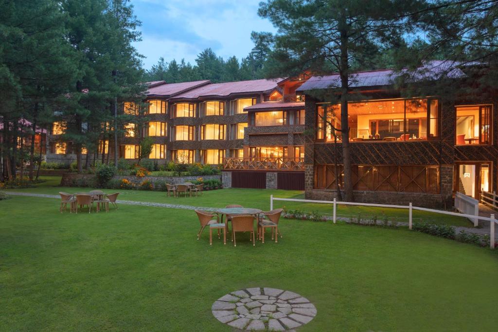 a large building with tables and chairs in a yard at Welcomhotel by ITC Hotels, Pine N Peak, Pahalgam in Pahalgām