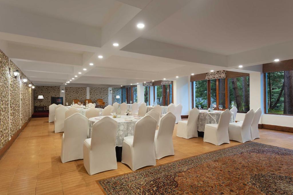 a banquet hall with white tables and white chairs at Welcomhotel by ITC Hotels, Pine N Peak, Pahalgam in Pahalgām