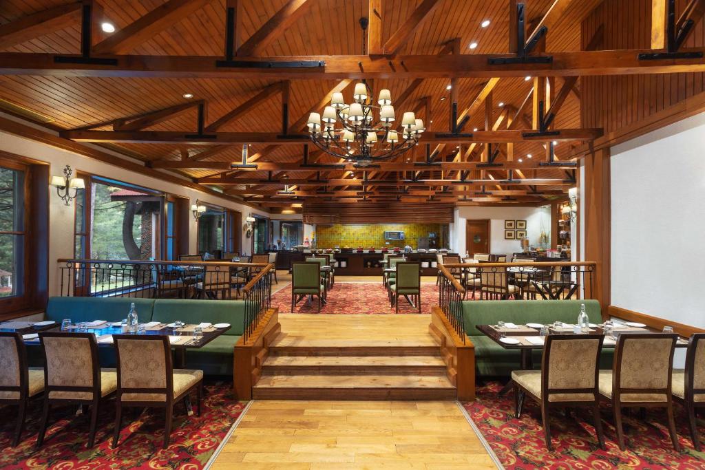 a restaurant with tables and chairs and a dining room at Welcomhotel by ITC Hotels, Pine N Peak, Pahalgam in Pahalgām